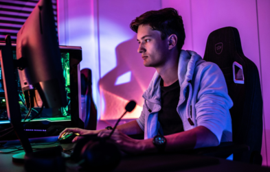 Young male gamer sitting at computer desk