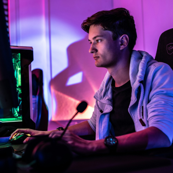 Young male gamer sitting at computer desk