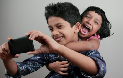 Two young kids playing with phone
